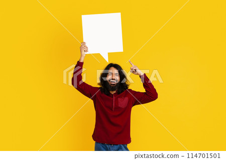 Indian man standing and holding a speech bubble above his head. The speech bubble is blank, indicating space for text. The man appears to be ready to speak or share a message. 114701501