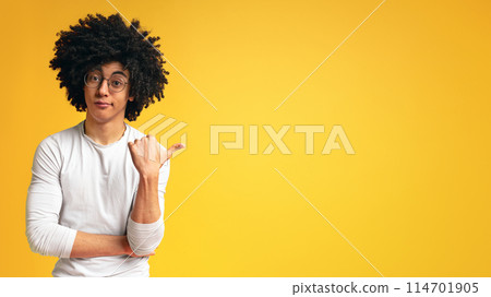 Did you see that. Skeptical african man pointing aside at empty space on orange panorama background Did you see that. Skeptical african man pointing aside at empty space on orange panorama background 114701905
