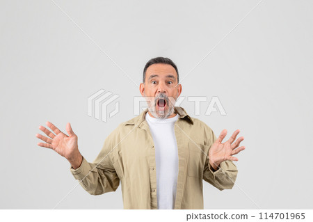 A senior man with a surprised look on his face, his eyebrows raised and mouth slightly open. He appears caught off guard by something unexpected. 114701965