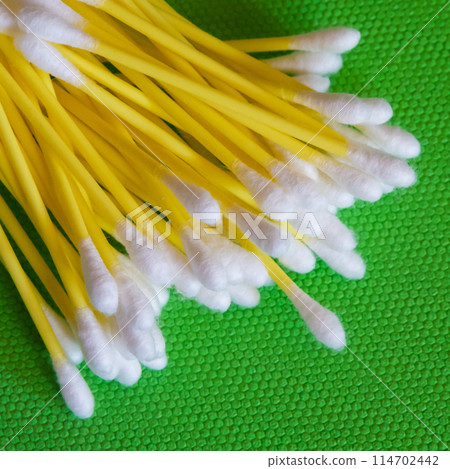 Cleaning Supplies. White-headed cotton swabs, vibrant green setting. Cleaning Supplies. White-headed cotton swabs, vibrant green setting. 114702442