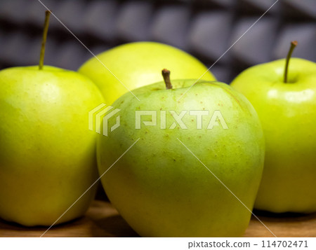 Fresh green apples, wooden surface, health-focused image. 114702471