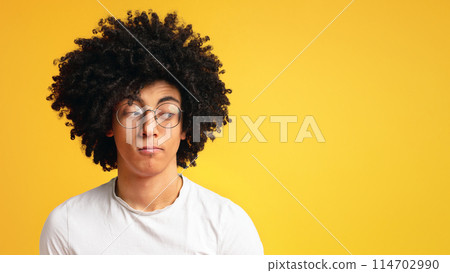 Skeptical young man, funny, suspicious annoyed looking aside at free space on orange background. On his own mind 114702990