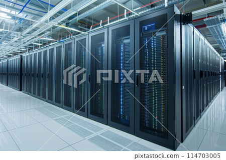Rows of servers fill a long building hallway in a data center 114703005