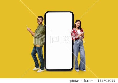 A man and woman Multiracial couple with a big blank smartphone screen for marketers on colorful studio background A man and woman Multiracial couple with a big blank smartphone screen for marketers on colorful studio background 114703055
