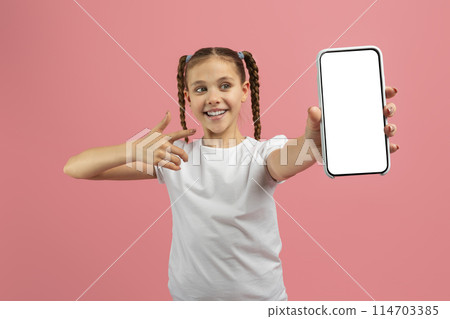 Caucasian teenager presenting a smartphone screen with a pointing gesture, isolated on pink, signifying accessible technology Caucasian teenager presenting a smartphone screen with a pointing gesture, isolated on pink, signifying accessible technology 114703385