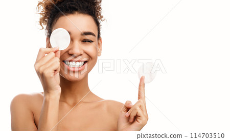 Beauty portrait of woman removing makeup with cotton pads isolated on white 114703510