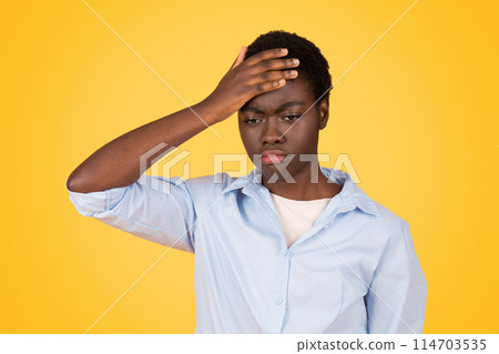 African American woman displays a gesture of suffering, her expression evoking the challenges that may face a zoomer Isolated on yellow background 114703535