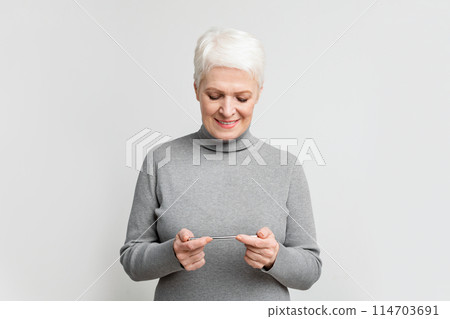 This image captures a senior European woman happily looking at her smartphone, reflecting s3niorlife's commitment to connecting the elderly with technology This image captures a senior European woman happily looking at her smartphone, reflecting s3niorlife's commitment to connecting the elderly with technology 114703691