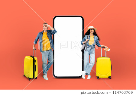 A man and woman travelers beside a gigantic phone screen on a red background, symbolizing the application of technology in planning trips 114703709