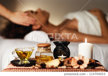 African woman having face massage, relaxing in spa salon and enjoying aroma therapy 114704053