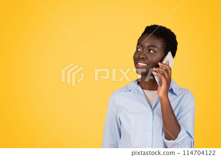 Engaged in communication, this generation z african american woman is using a smartphone, signifying the importance of connectivity, isolated, copy space 114704122
