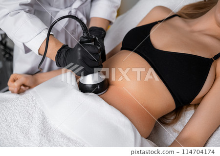 Vacuum procedure after ultrasound cavitation of the abdomen for young woman 114704174