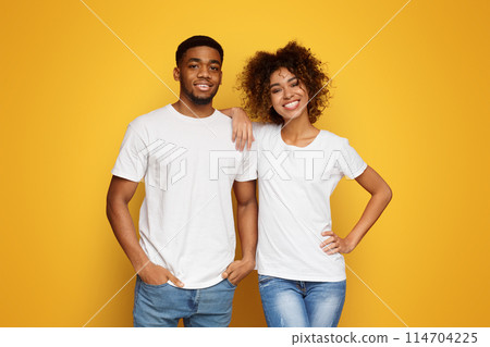 Happy couple. African american man and woman smiling on orange studio background Happy couple. African american man and woman smiling on orange studio background 114704225
