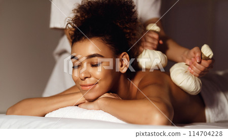 Body care. Spa body massage with hot herbal balls for deep relaxation 114704228