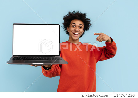 An enthusiastic african american presenting a laptop screen, isolated on blue, perfect for mockups and advertising spaces 114704236