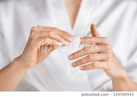 A millennial woman is captured applying a skin care product in her bright, soothing bathroom, focusing on self-care and beauty routines, doing manicure A millennial woman is captured applying a skin care product in her bright, soothing bathroom, focusing on self-care and beauty routines, doing manicure 114704543