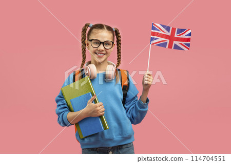 A teen girl holding the United Kingdom flag, representing an interest in British culture or language apart from schooling 114704551