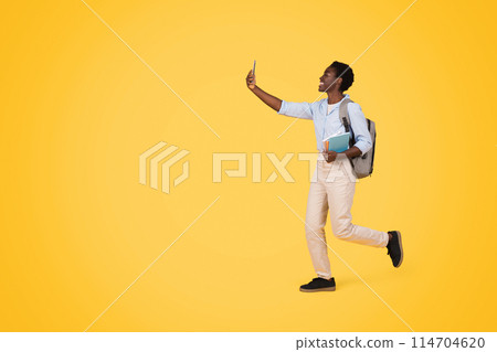 Capturing a moment, this image showcases a generation z african american woman taking a selfie, indicating the significance of social media, isolated 114704620