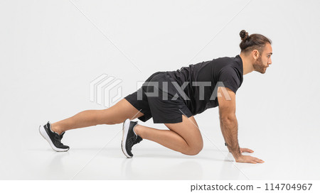 Determined man in a black outfit performing push-ups with an emphasis on form and strength over a clear background Determined man in a black outfit performing push-ups with an emphasis on form and strength over a clear background 114704967