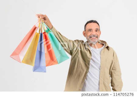 A smiling older man displays multiple colored shopping bags, indicating a pleasant shopping experience or sales concept A smiling older man displays multiple colored shopping bags, indicating a pleasant shopping experience or sales concept 114705276