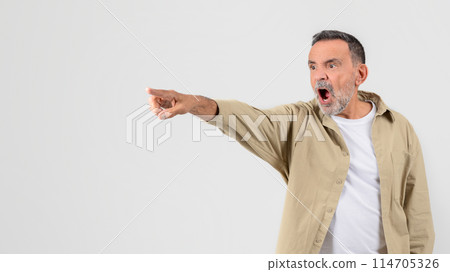 Astonished older man pointing with one hand, mouth open in shock on a clear white background, copy space Astonished older man pointing with one hand, mouth open in shock on a clear white background, copy space 114705326