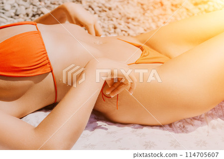 Happy woman taking red bikini off on beach for tan, lady stripping holiday swimsuit with bow in string. Fun, beauty and relax, sexy model untying swimming costume bra, girl in swimwear on vacation Happy woman taking red bikini off on beach for tan, lady stripping holiday swimsuit with bow in string. Fun, beauty and relax, sexy model untying swimming costume bra, girl in swimwear on vacation 114705607