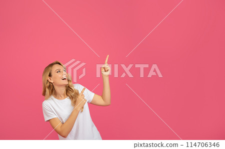 Look Up. Excited Blonde Young Woman Pointing Fingers Upward At Copy Space For Text Offer, Advertising Discount Or Great Deal Over Pink Studio Background. Advertisement Banner 114706346