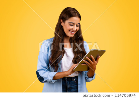 Glad european teenager student, pupil, manager woman, typing on tablet, chatting, watch online lesson, isolated on yellow background, studio. Learn, education and video call app Glad european teenager student, pupil, manager woman, typing on tablet, chatting, watch online lesson, isolated on yellow background, studio. Learn, education and video call app 114706974