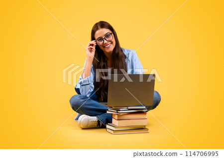 Happy european teenager student woman in glasses use computer with books, typing, study at floor, isolated on yellow background, studio, full length. Work online, education and lesson remotely Happy european teenager student woman in glasses use computer with books, typing, study at floor, isolated on yellow background, studio, full length. Work online, education and lesson remotely 114706995