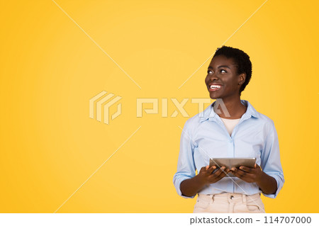 Cheerful young african american woman student in casual typing on tablet, enjoy online lesson, look at free space, isolated on yellow studio background. Study and education, app, ad and sale Cheerful young african american woman student in casual typing on tablet, enjoy online lesson, look at free space, isolated on yellow studio background. Study and education, app, ad and sale 114707000