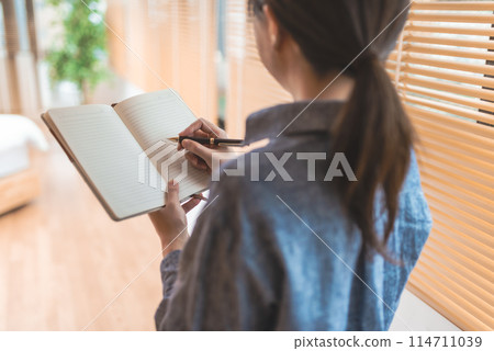 拿著筆記本的女人 114711039