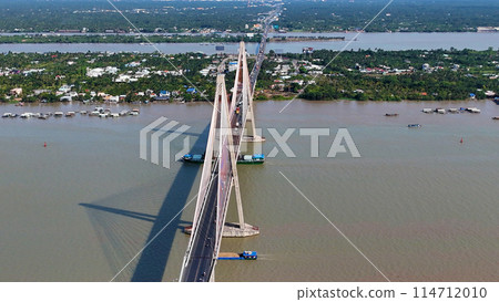 Aerial view of Rach Mieu Bridge cross Tien river, link Tien Giang with Ben Tre, cable stayed bridge at Mekong Delta, boat traffic on water, vehicle on road Aerial view of Rach Mieu Bridge cross Tien river, link Tien Giang with Ben Tre, cable stayed bridge at Mekong Delta, boat traffic on water, vehicle on road 114712010