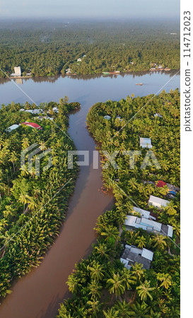 Beautiful aerial view of Mekong Delta countryside, coconut land with vast coconut, nipa palm jungle, riverside house and waterway transport good for Vietnam ecotourism at Ben Tre Beautiful aerial view of Mekong Delta countryside, coconut land with vast coconut, nipa palm jungle, riverside house and waterway transport good for Vietnam ecotourism at Ben Tre 114712023
