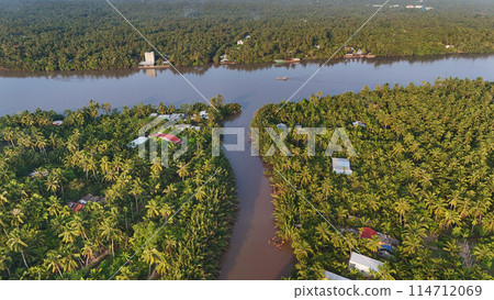 Beautiful aerial view of Mekong Delta countryside, coconut land with vast coconut, nipa palm jungle, riverside house and waterway transport good for Vietnam ecotourism at Ben Tre Beautiful aerial view of Mekong Delta countryside, coconut land with vast coconut, nipa palm jungle, riverside house and waterway transport good for Vietnam ecotourism at Ben Tre 114712069