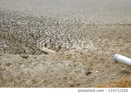 Dried soil surface, waterless sewer pipes after long time hot season at Mekong Delta, Viet Nam, climate change and el nino make hard weather of global, drought field affect to food Security 114712208