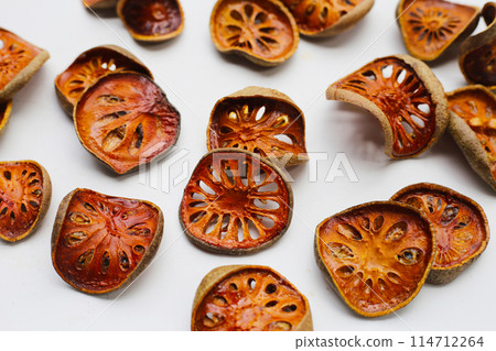 Dried bael fruit slices on white background. 114712264