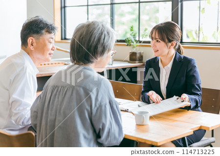 Business woman having a meeting with a couple Business woman having a meeting with a couple 114713225