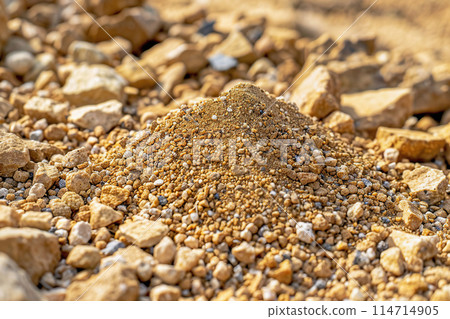 Texture of decomposed granite stones, highlighting varying sizes and colors in a natural setting 114714905
