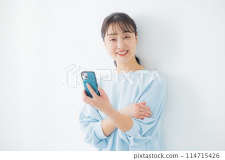 A middle-aged woman operating a smartphone 114715426