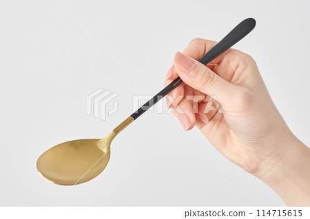 Woman's hand holding a spoon Woman's hand holding a spoon 114715615