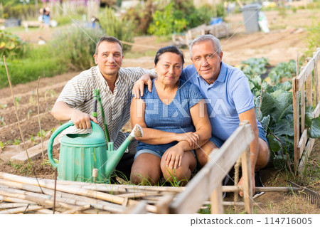 Happy elderly parents and adult son enjoying favorite pastime in garden Happy elderly parents and adult son enjoying favorite pastime in garden 114716005