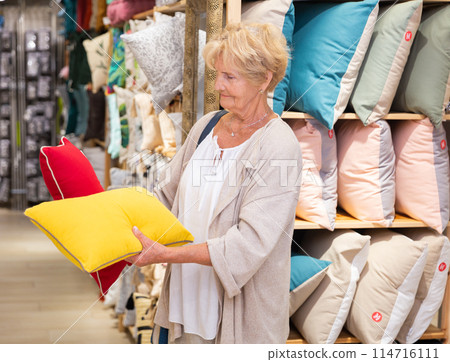 Mature woman choosing pillow at household shop 114716111