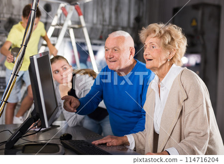Kids and their grandparents solving riddles in escape room 114716204