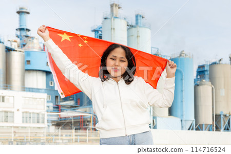 Happy young woman with flag of China against background of factory 114716524