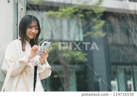 在城裡操作智慧型手機的年輕女性 114716550