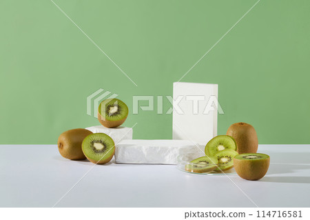 An empty stone podium arranged on the surface with other white podiums with a lot of kiwi fruits. Kiwis are a powerhouse of vitamins that can help keep your heart and digestive system healthy 114716581