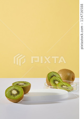 Concept of healthy skin with slices and halves of kiwi displayed with a podium on yellow background. Vacant space on the podium to show product of Kiwi fruit extract 114716588