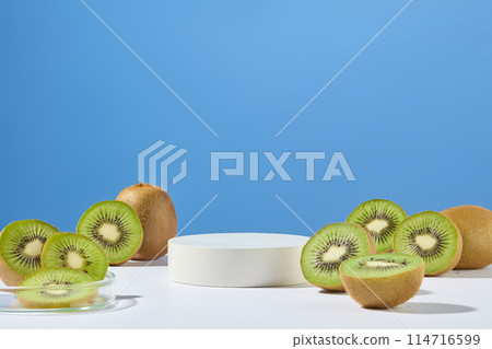 An empty podium in round shaped surrounded by a lot of kiwi halves. Front view. Blue background. Kiwis are packed with antioxidants like vitamin C and vitamin E An empty podium in round shaped surrounded by a lot of kiwi halves. Front view. Blue background. Kiwis are packed with antioxidants like vitamin C and vitamin E 114716599