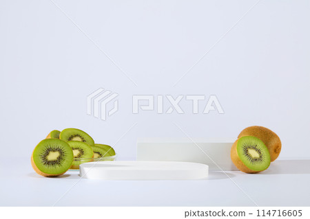 Two podium in round and rectangle shaped are displayed over the white background with delicious kiwis. Collection of podiums and pedestals for product advertising 114716605