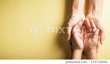 Studio shot, Close-up top view of family hands stacked isolated background. Parents and kid holding empty space together symbolizing support and love. Family and Parents Day concept. 114716948